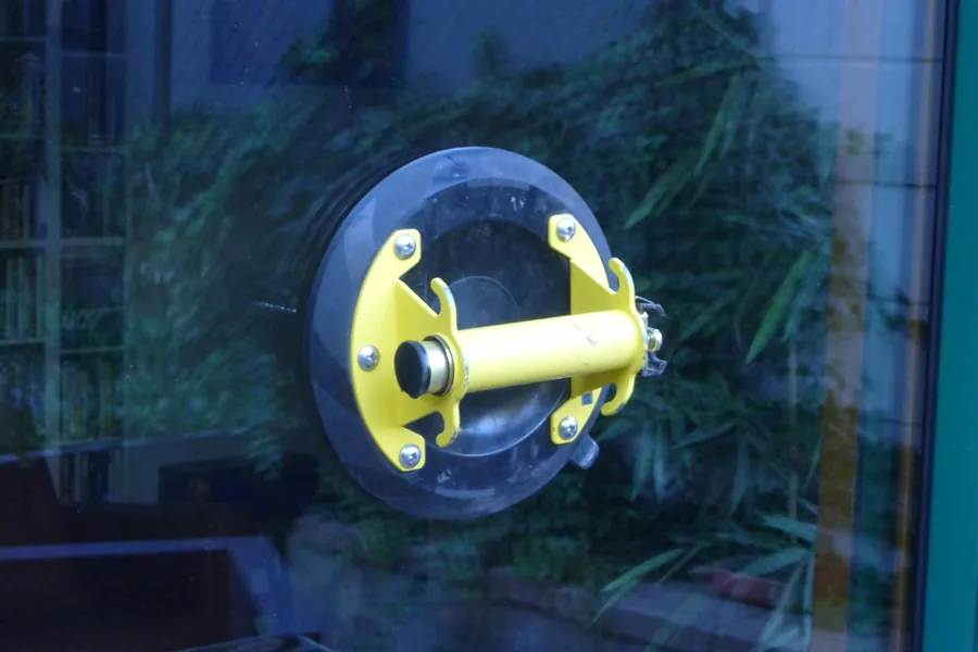 Ventouse de vitrier jaune fixée sur une vitre